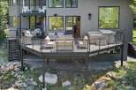 Experience luxury outdoor living with this stunning multi-level deck, featuring a relaxing hot tub and ample seating areas perfect for entertaining.