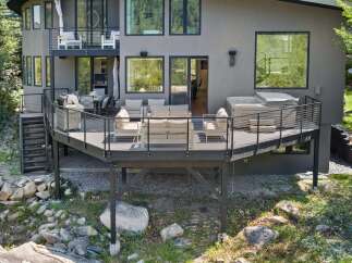 Experience luxury outdoor living with this stunning multi-level deck, featuring a relaxing hot tub and ample seating areas perfect for entertaining.