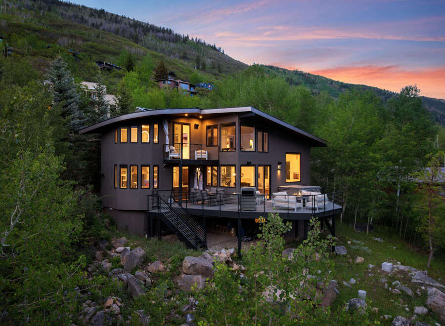Experience luxury mountain living in this stunning contemporary home, nestled amidst lush greenery and offering breathtaking sunset views.