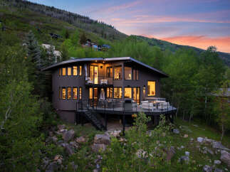 Experience luxury mountain living in this stunning contemporary home, nestled amidst lush greenery and offering breathtaking sunset views.