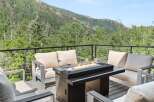 Experience breathtaking mountain views from this stunning deck, complete with a modern fire pit and comfortable seating.