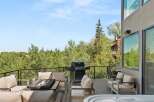 Experience luxury outdoor living with this stunning deck featuring a spacious hot tub and a sleek gas grill, perfect for entertaining.