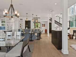Experience modern luxury in this open-concept living space, featuring a sleek kitchen island with bar seating and a striking mosaic backsplash.