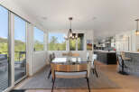 Experience modern living in this stunning home featuring a spacious dining area with a sleek glass-top table and comfortable seating, perfect for entertaining.