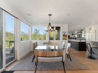 Experience modern living in this stunning home featuring a spacious dining area with a sleek glass-top table and comfortable seating, perfect for entertaining.