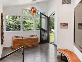 Step into this stunning entryway featuring a vibrant, multi-colored glass chandelier that immediately captures attention.