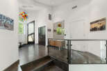 Step into this modern entryway featuring a striking multi-colored glass chandelier that adds a vibrant pop of color.