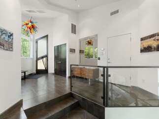 Step into this modern entryway featuring a striking multi-colored glass chandelier that adds a vibrant pop of color.