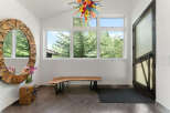 Step into this welcoming entryway featuring a striking live-edge wood bench and a unique, artistic chandelier.