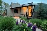 Discover modern mountain living in this stunning architectural home, featuring a unique metal exterior and a welcoming entryway with vibrant art.