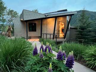 Discover modern mountain living in this stunning architectural home, featuring a unique metal exterior and a welcoming entryway with vibrant art.