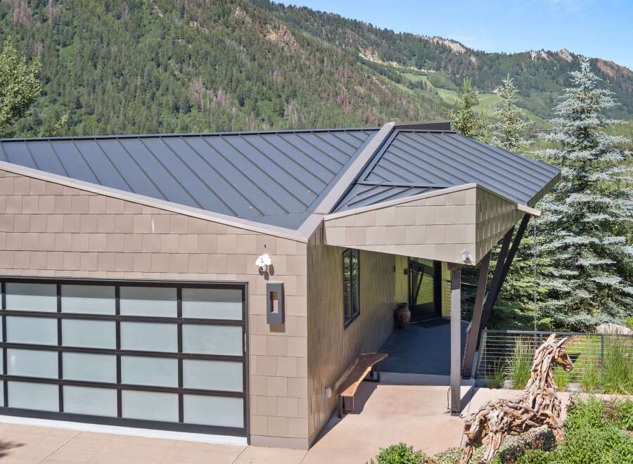Experience modern mountain living in this stunning home, featuring a sleek metal roof and contemporary siding.
