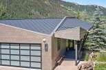 Experience modern mountain living in this stunning home, featuring a sleek metal roof and contemporary siding.