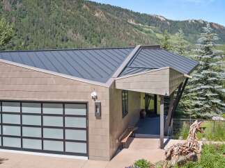 Experience modern mountain living in this stunning home, featuring a sleek metal roof and contemporary siding.