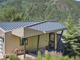 Experience modern mountain living in this stunning home, featuring a sleek metal roof and unique architectural design.