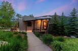 Experience modern mountain living in this stunning architectural home, featuring a unique metal exterior and a dramatic angled roofline.
