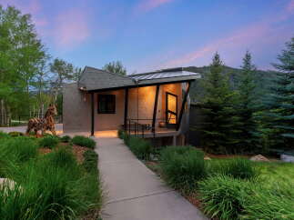 Experience modern mountain living in this stunning architectural home, featuring a unique metal exterior and a dramatic angled roofline.