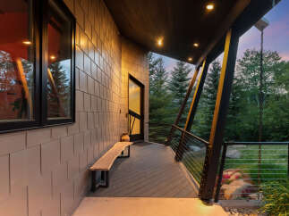 Experience modern living with this stunning property featuring a sleek exterior and a spacious covered porch.