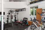 This spacious garage offers a dedicated home gym area with a Marcy weight machine, adjustable bench, and a full set of dumbbells, perfect for your fitness routine.