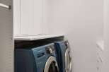 Discover modern convenience in this laundry room, featuring a stacked Samsung washer and dryer set in a sleek blue finish.