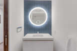 Experience modern elegance in this bathroom, featuring a sleek white vanity with an integrated sink.