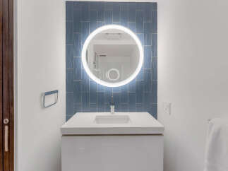 Experience modern elegance in this bathroom, featuring a sleek white vanity with an integrated sink.