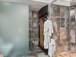 Experience ultimate relaxation in this luxurious bathroom featuring a private sauna and a spacious glass-enclosed shower.