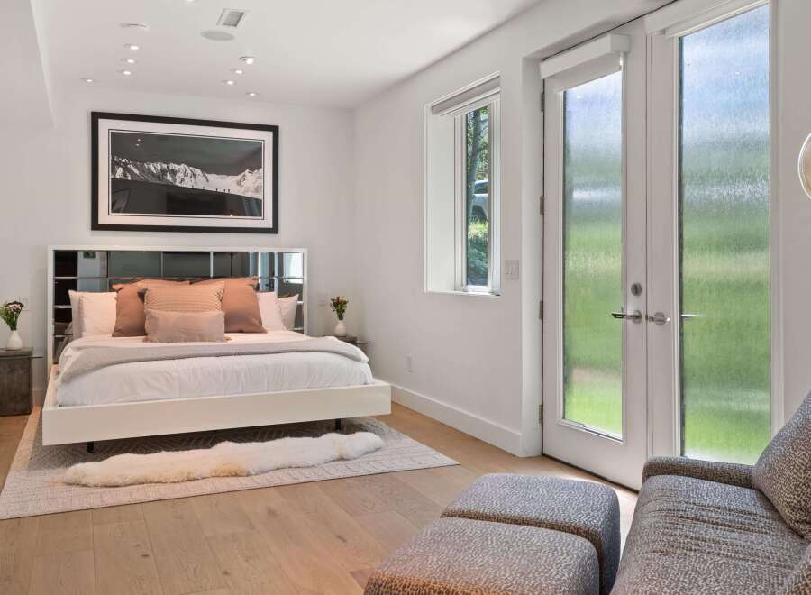 Experience modern luxury in this serene bedroom, featuring a sleek platform bed adorned with plush pillows and a soft throw.