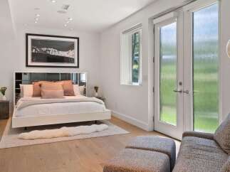 Experience modern luxury in this serene bedroom, featuring a sleek platform bed adorned with plush pillows and a soft throw.