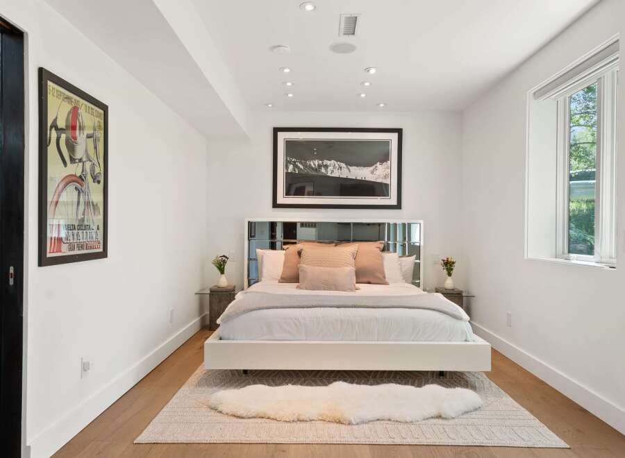 Experience modern comfort in this beautifully appointed bedroom, featuring a plush king-sized bed adorned with elegant throw pillows.