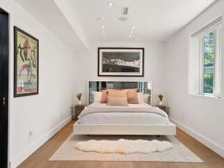 Experience modern comfort in this beautifully appointed bedroom, featuring a plush king-sized bed adorned with elegant throw pillows.