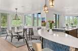 Experience luxury living in this stunning open-concept kitchen and dining area, featuring a sleek white quartz island with a striking blue mosaic tile backsplash.
