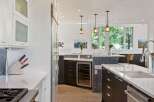 Experience luxury in this modern kitchen featuring sleek dark wood cabinetry and a spacious white quartz island.