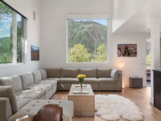 Experience breathtaking mountain views from this stunning living room, featuring a spacious sectional sofa perfect for relaxation.