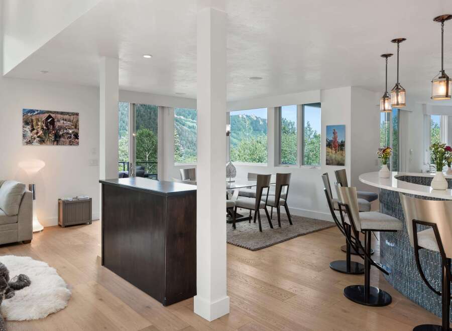 Experience modern living in this open-concept space featuring a sleek kitchen island with bar seating and a separate dining area.