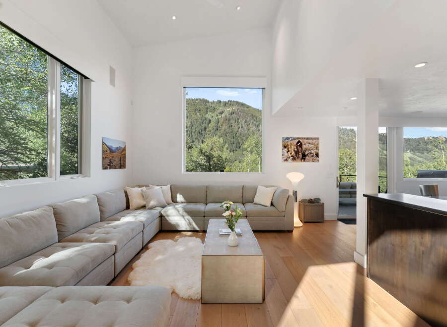 Experience breathtaking mountain views from this stunning living room, featuring a large sectional sofa perfect for relaxation.