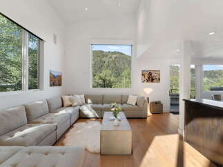 Experience breathtaking mountain views from this stunning living room, featuring a large sectional sofa perfect for relaxation.