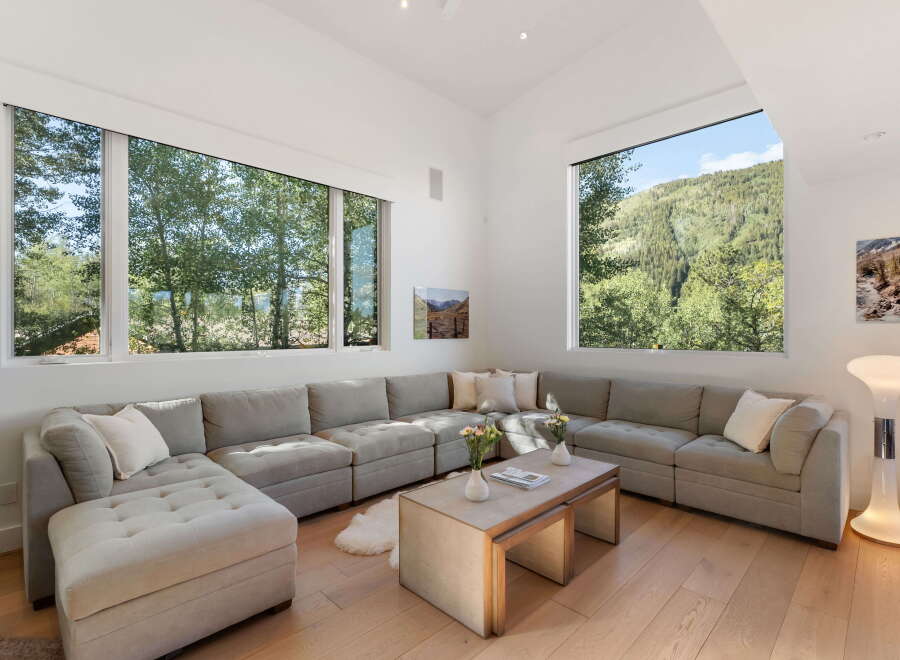 Experience breathtaking mountain views from this stunning living room, featuring a spacious sectional sofa perfect for relaxation.