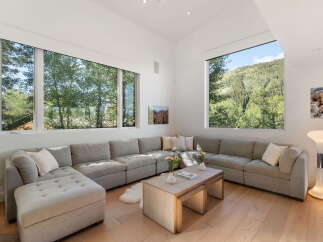 Experience breathtaking mountain views from this stunning living room, featuring a spacious sectional sofa perfect for relaxation.