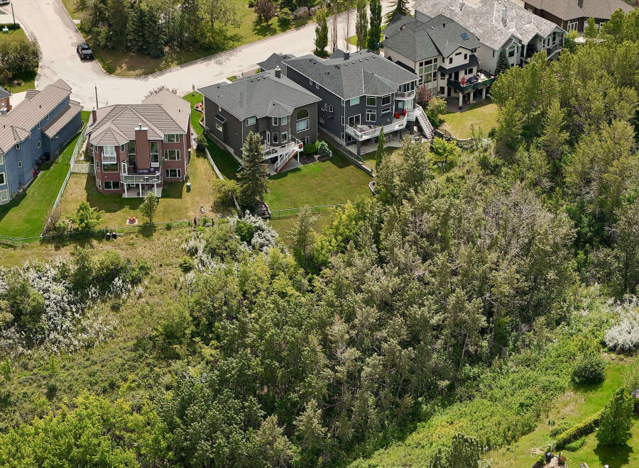 Discover luxury living in this stunning aerial view of a multi-story home with a dark gray exterior and a spacious backyard.