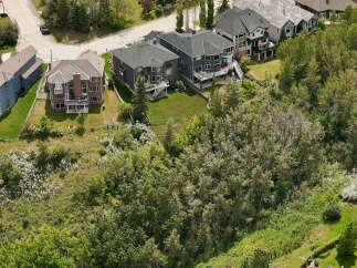 Discover luxury living in this stunning aerial view of a multi-story home with a dark gray exterior and a spacious backyard.
