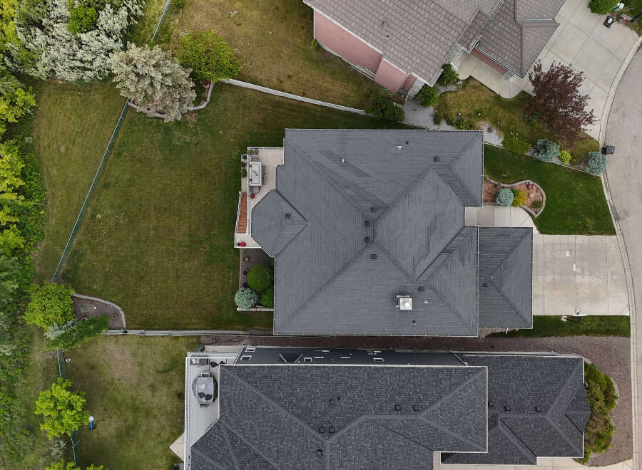 Experience luxury living in this stunning aerial view showcasing a modern home with a spacious backyard and a well-maintained lawn.