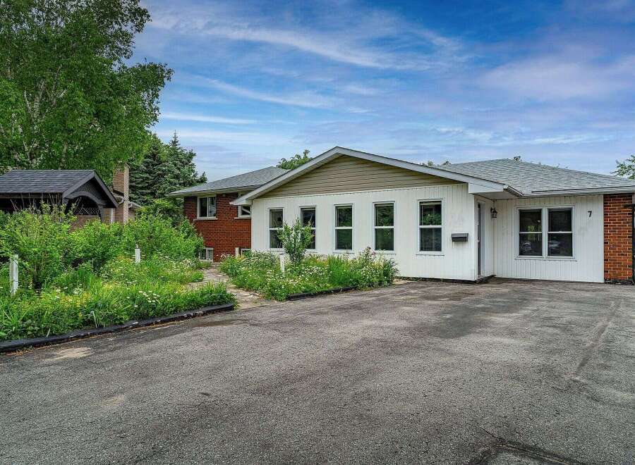 Discover this charming property featuring a welcoming exterior with a mix of brick and white siding.