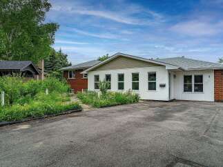 Discover this charming property featuring a welcoming exterior with a mix of brick and white siding.