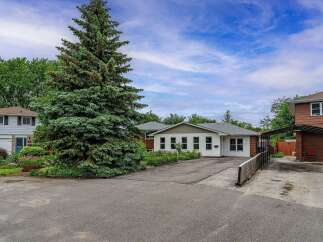 Discover this charming property featuring a spacious driveway leading to a well-maintained home with a large evergreen tree providing ample privacy.