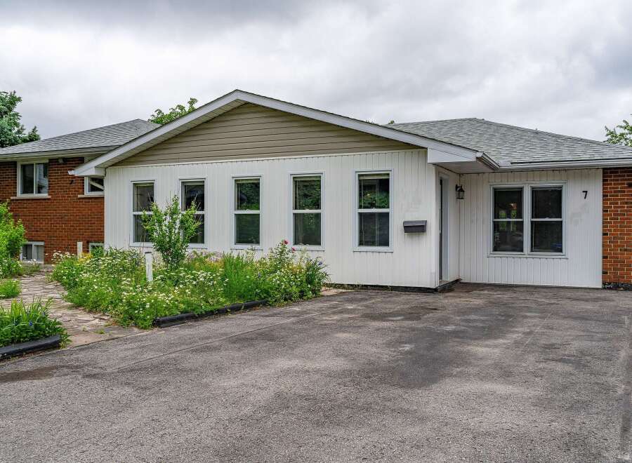 Charming single-family home featuring a welcoming facade with white siding and brick accents.