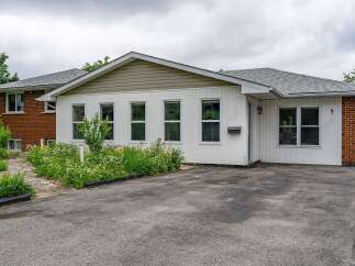 Charming single-family home featuring a welcoming facade with white siding and brick accents.