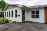 Charming single-family home featuring a welcoming facade with white vinyl siding and a classic brick accent.