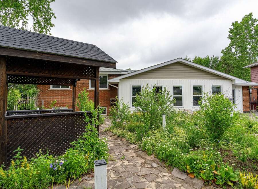Discover this charming property featuring a lovely gazebo and a stone pathway leading through lush greenery.