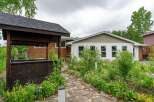 Discover this charming property featuring a lovely gazebo and a stone pathway leading through lush greenery.